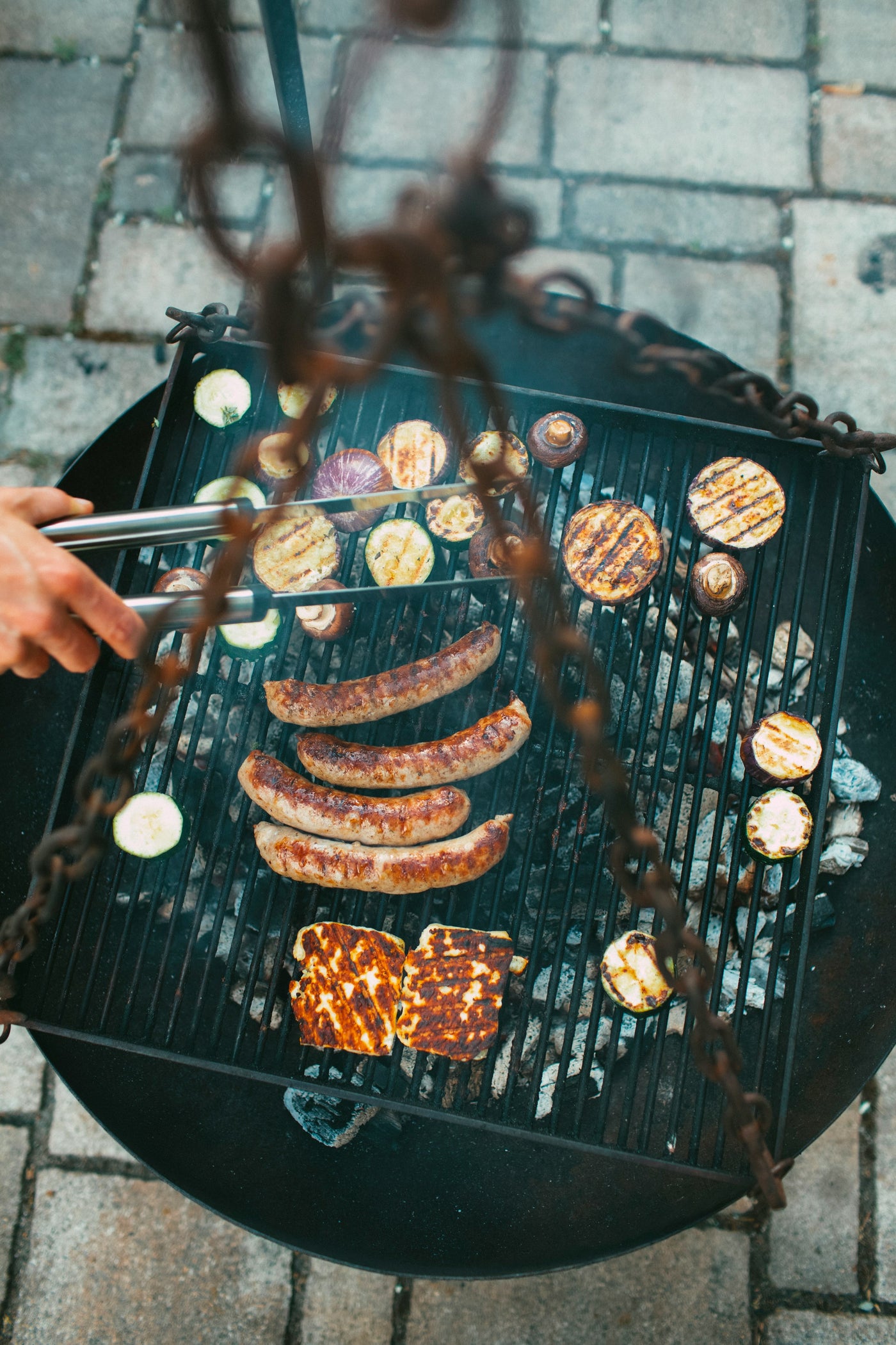 Eine Grillplatte mit Bratwürsten, Steaks, Salat, Folienkartoffeln und Corn Ribs auf einem Grill im Kliemannsland.