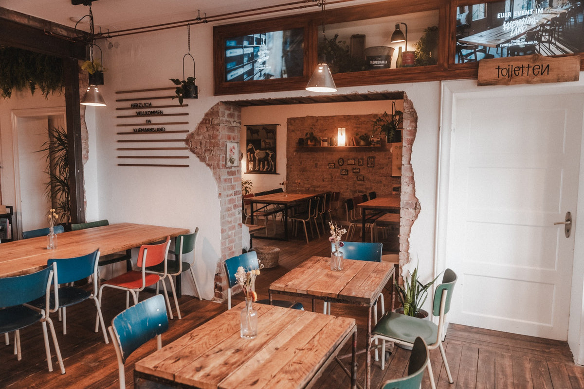 Gastraum im Café Dübel im Kliemannsland mit Holztischen und bunten Stühlen