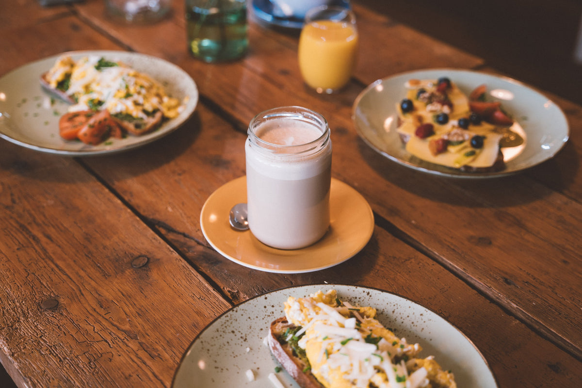 Frühstückstisch mit Pfannkuchen, Getränken und Gerichten im Café
