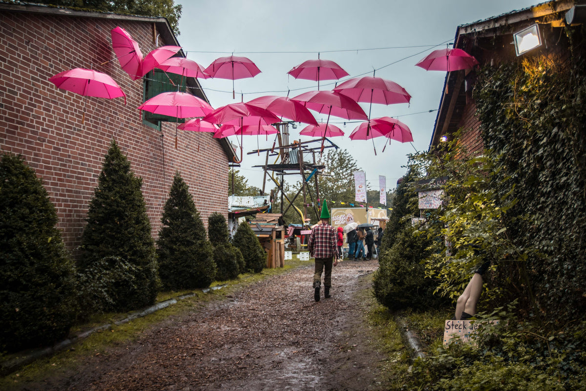 Weg mit pinken Schirmen über dem Hof im Kliemannsland