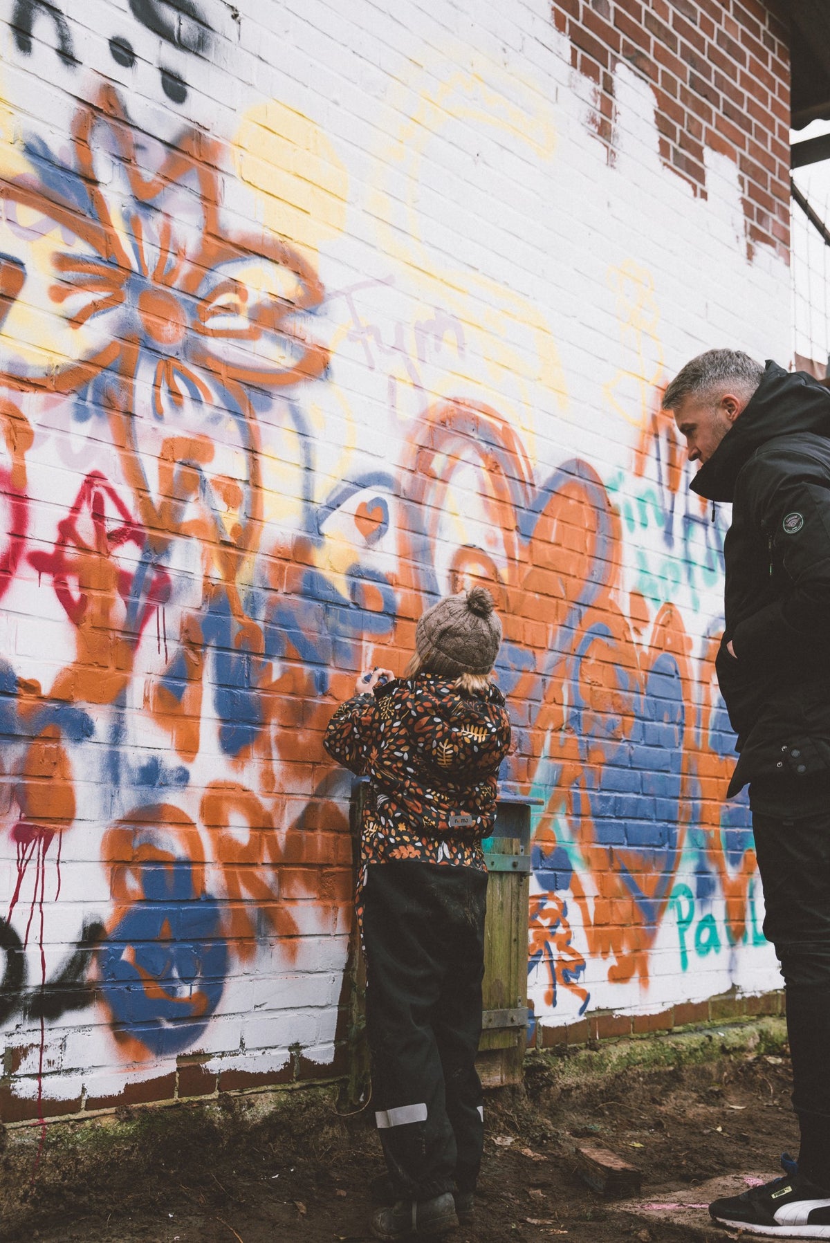 Besucher sprühen bunte Graffiti an die Wand