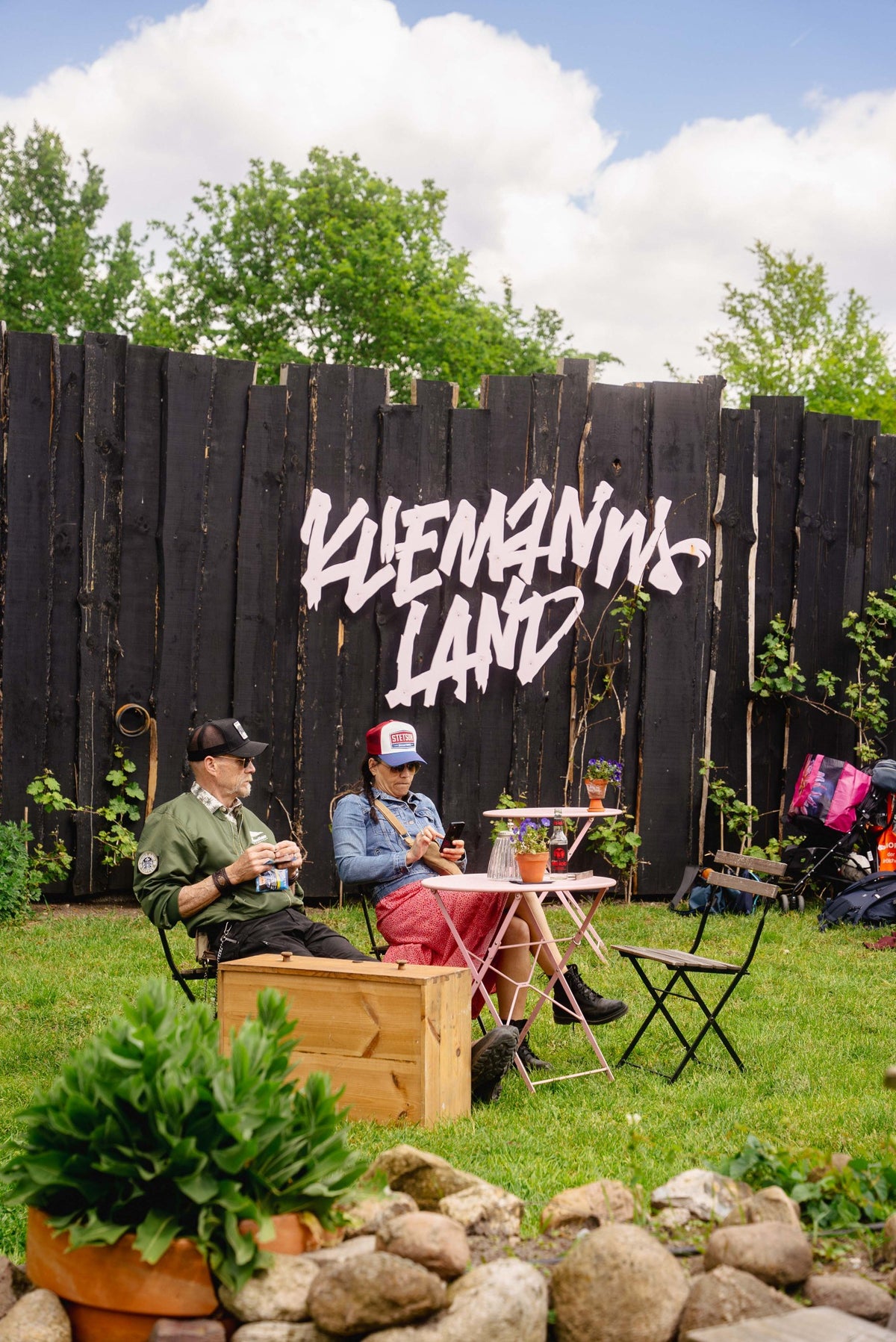 Gäste sitzen vor der Kliemannsland-Wand im Garten