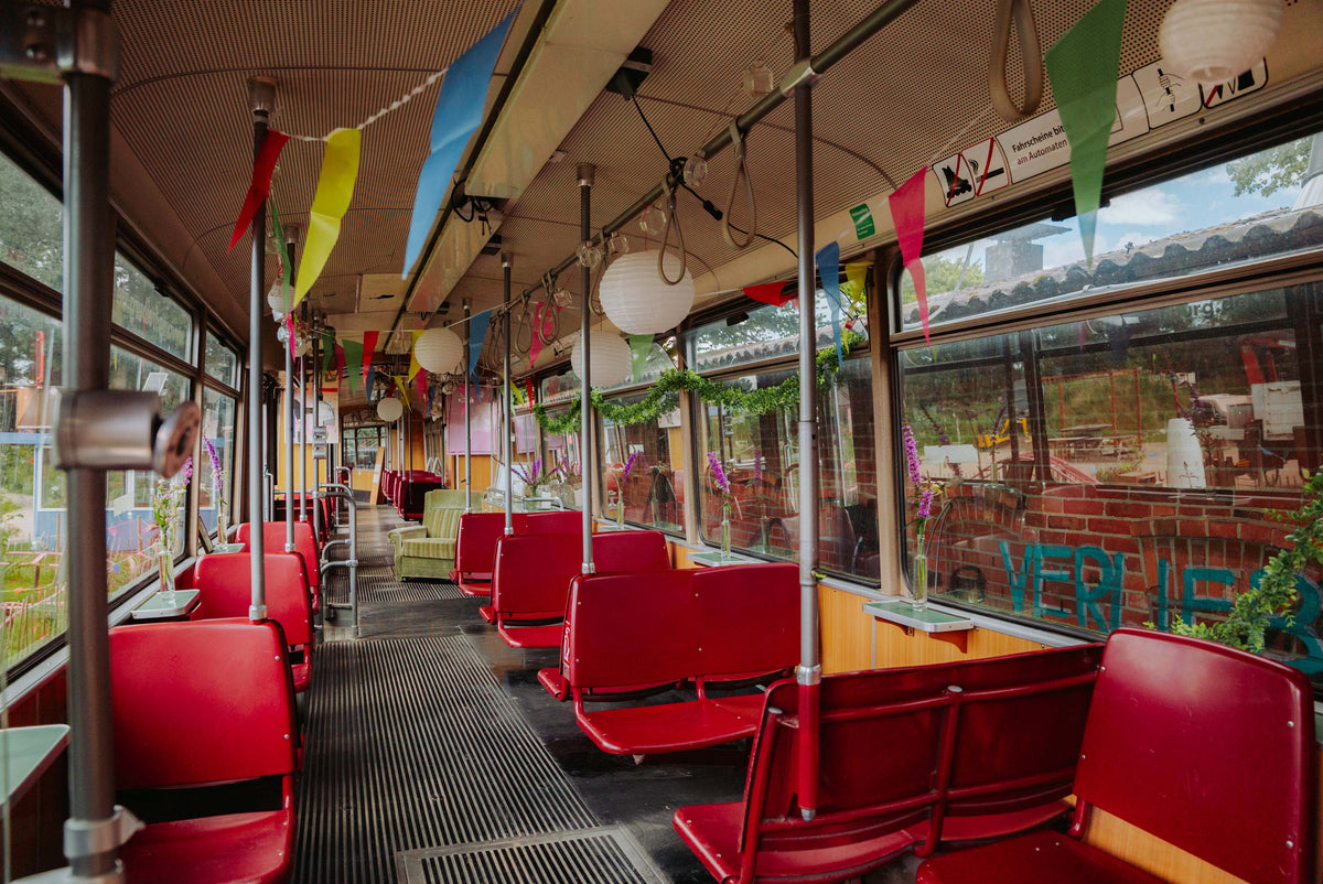 Innenraum der Straßenbahn im Kliemannsland mit roten Sitzen und Wimpeln