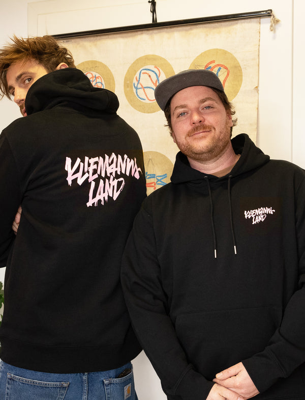 Zwei Personen im schwarzen Kliemannsland Hoodie, einer zeigt den Rückenprint